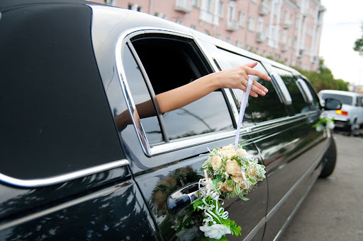 bride hands hanging out of limo window