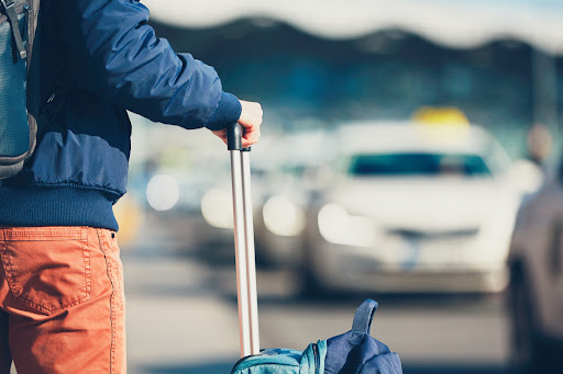 man holding luggage waiting at airport